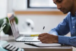 Meja kerja dengan laptop, catatan riset, dan checklist editorial untuk menjaga kualitas artikel