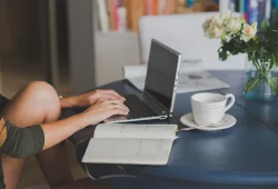 Laptop dan catatan perencanaan nama domain untuk blog di meja kerja
