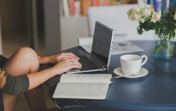 Laptop dan catatan perencanaan nama domain untuk blog di meja kerja