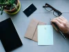 Laptop dan ponsel di meja kerja menampilkan tata letak blog yang sederhana