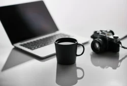 Meja kerja blogger dengan laptop dan dashboard situs yang tertata