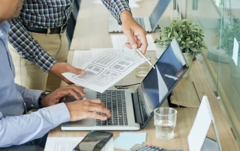 Meja kerja blogger dengan laptop dan catatan untuk merencanakan website